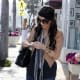Kim Kardashian wearing ripped and torn tight jeans and high heel pumps
