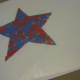 With the second paper star placed on top of the tissue paper, and another piece of clear contact paper on top of that.