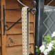 The completed hanging bird feeder hanging from a wall bracket.
