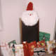 Here the Santa face perches on a stereo speaker. Surrounded by gifts, it takes the place of a Christmas tree in an apartment that is short on space.