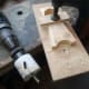 Using sacrificial wood for grip for the drill bit, so as to use a hole cutter saw for creating the curved base of the stand.