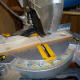 Using a mitre saw to cut the wood to the desired length.