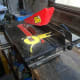 Using a tape measure to set up the bench saw for cutting the wood to the desired width.