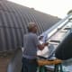 A crew member studies the lid components and decides a course of action.
