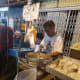 Street vendor preparing the Ding Ding Candy (a hard maltose candy with sesame and ginger flavours)