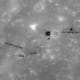 July 2010 - At high noon, the glare off bits of the Orion descent module (LM), buggy (LRV) and instruments looks like white spots in the camera lens. Astronaut tracks are dark.