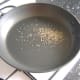 Cumin seeds are toasted in a hot, dry frying pan