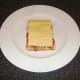 Cheese is placed on the sandwich which is now ready for grilling/broiling