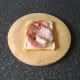 Bacon is laid on first slice of bread