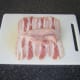 Chicken breast fillet is laid on pancetta and sliced open along the centre