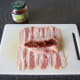 Sun dried tomatoes are laid in groove in chicken breast fillet