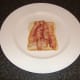 Bacon is laid on first slice of bread