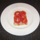 Tomato slices are laid on top of bacon