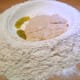 When the yeast is ready, add it into flour. Add olive oil.