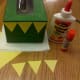 Glue 3 triangles to the front of each box.