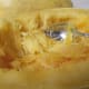 Scraping the cooked spaghetti squash into a bowl.