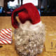 Position your old stocking or Santa hat on top of your container and secure it with hot glue.