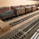 Fiddleyard B:on the Thoraldby (cf) layout: A line-up of divers British Railways' and ex-LNER goods and perishables vans (fruit/meat) with a B R low-sided wagon and tarpaulined load this end.