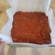 Step Eight: Pour your brownie batter into the parchment paper lined dish and spread out evenly.