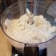Then I pull my coconut oil out of the freezer and break it all into small pieces. I add that to my processor and process that in as well.