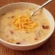 When finished, mash the potatoes in your soup with a potato masher. Then drop in your cream cheese and shredded cheese and stir until melted. Top with more cheese, bacon and chives if you'd like.