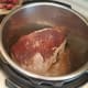 Flip after 5 minutes or so, and one side is browned. Then add in half of your beef broth and scrape the bottom of the pot with a plastic spatula.