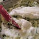 Folding the whipped egg whites into the spinach and goat cheese mixture
