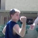 The defender pulls his wrist out and back towards his right shoulder to escape the grip of his attacker