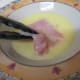 Dip the flattened chicken thigh in the egg and water mixture