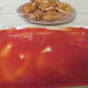 A layer of herbed tomato sauce on the bottom of a baking dish