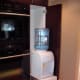 water cooler tucked behind wood cabinets - hidden filtered water