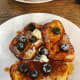 Homemade French toast served with butter, fresh blueberries, and maple syrup