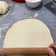 Use a rolling pin to roll one of the dough balls into a thin,10-inch circle.