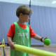 Boy in green hits ball off air tee