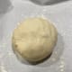Once the dough is formed, transfer it onto a parchment-lined pan or baking tray.