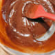 Gently stir the mixture with a spatula until the chocolate melts.