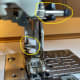 Secure the clip to the side, and slip the forked tine over the needle bar.
