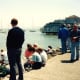 Water view from Sausalito - People eating pizza by the slice, ice cream cones, etc., while sitting on the rocks and sidewalk watching the different boats on the water.