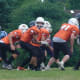 During Wolverines rep football, at the line of scrimmage, the quarterback has just received the ball.