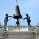 A close up of the statues and the bell on the clock tower.
