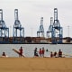 The cranes and freight containers of Puerto de la Luz across the water from Playa de las Alcaravaneras.