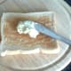 Garlic and tarragon butter is spread on hot toast