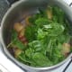 Baby spinach leaves are laid on top of hot potatoes