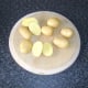 New potatoes are cut in half lengthways
