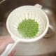 Peas are seasoned in the draining colander
