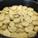 Arrange the sliced potatoes in a baking dish.