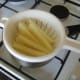Parboiled potatoes are carefully drained in a colander or large sieve