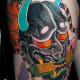 A colorful black hannya tattoo.