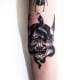 A hannya mask tattoo that incorporates a snake.