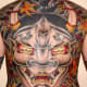 A large, symmetrical hannya mask tattoo on the back.
